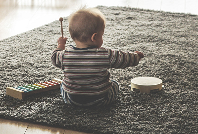 a baby playing a toy drum