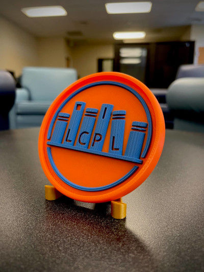 A 3D printed medallion with the LCPL logo on it