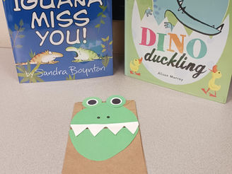 The two books pictured with a dinosaur paper bag puppet