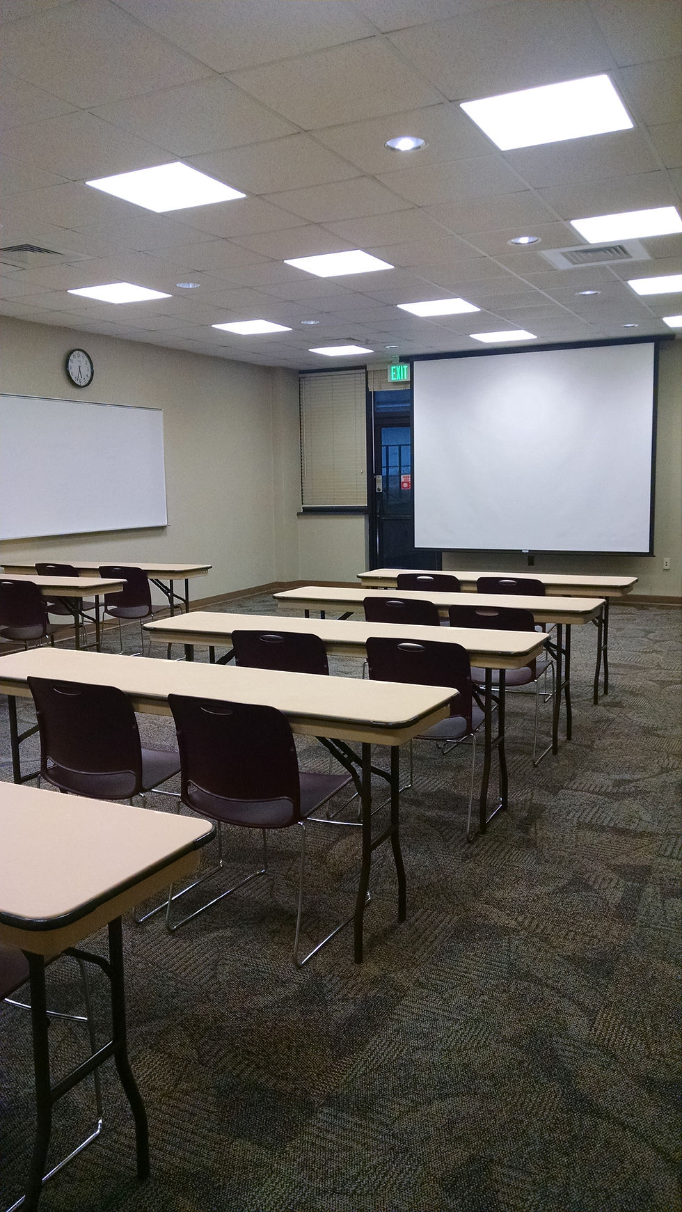 Tables and chairs facing a projector screen