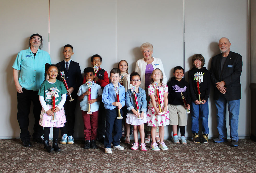 A row of kids proudly hold up their trophies with Foundation members smiling in the back