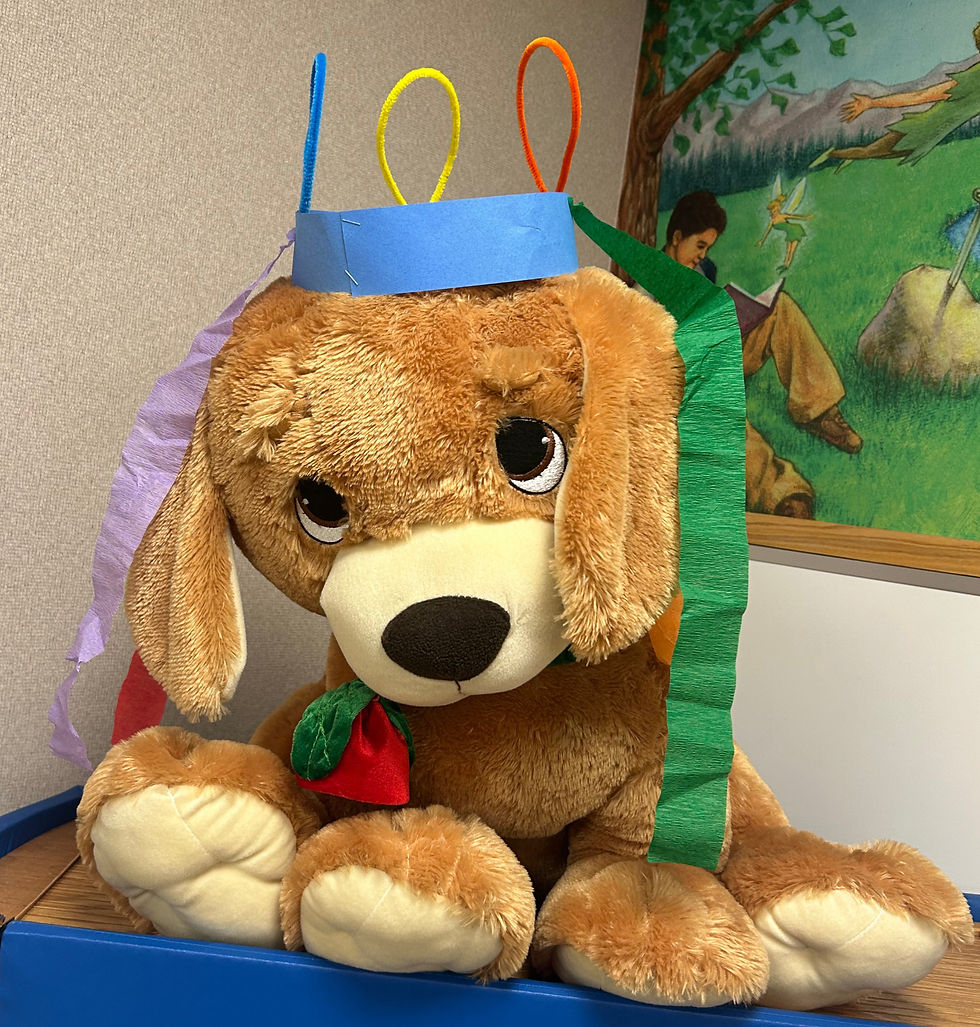 A plush dog wearing the hat created by following the steps above. It has pipe cleaners sticking out of the top in loops and colorful streamers handing down