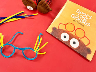 The book cover shows the top half of a bear's head with glasses restion on top. The craft is pictured next to the book