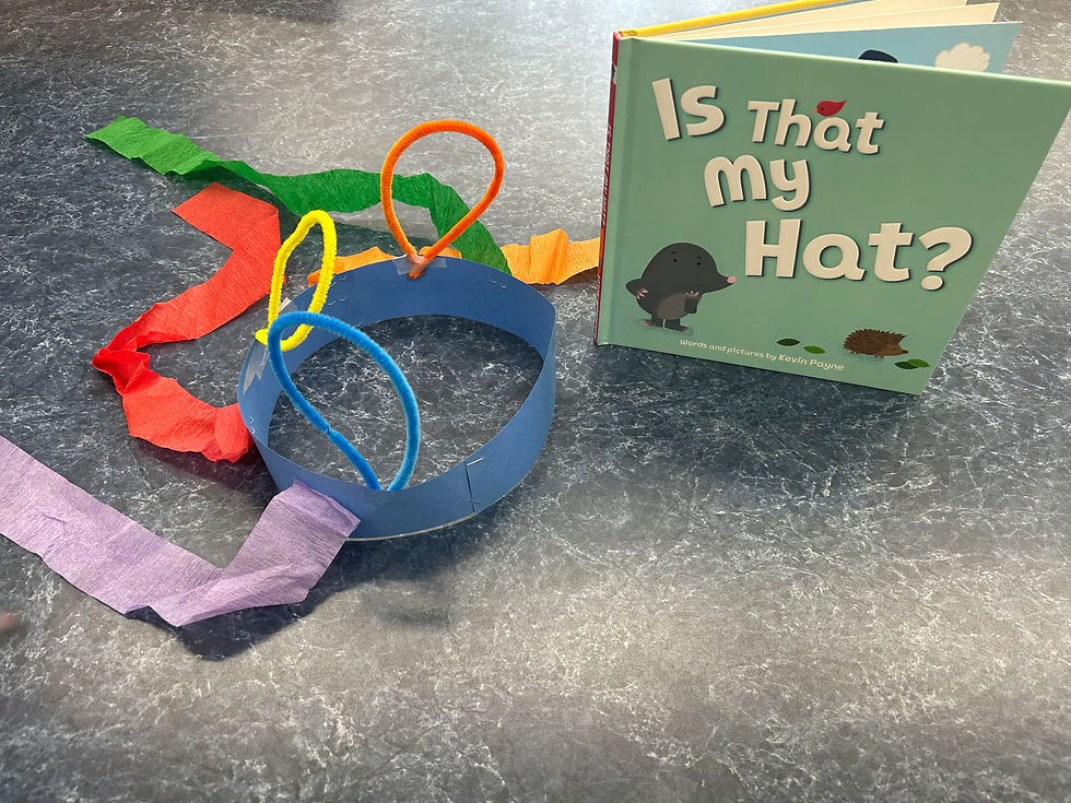 The hat craft shown with the book. The hat is made of paper strips stapled together into a headband, with streamers and pipe cleaners decorating it. The book shows a mole looking mildly perplexed