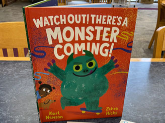 The book shows a green monster skateboarding across the cover, while a child watches with wide eyes. 
