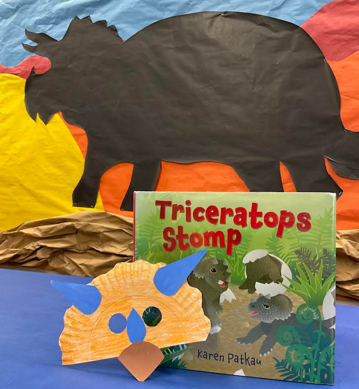 The picture book shows baby triceratops emerging from eggs. It is pictured with the craft described below