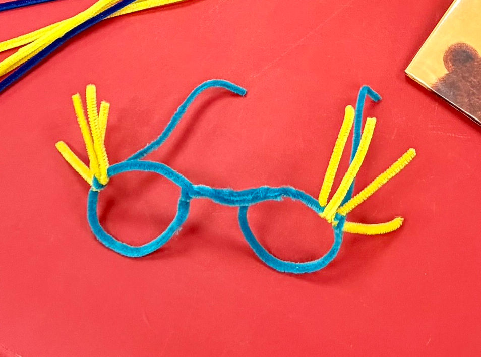 Pipe cleaners twisted into the shape of glasses, with additional ones added as wing-like decoration