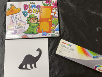 The book cover shows a child in a dinosaur costume holding a crayon and approaching a door, while dinosaurs and flowers peek in from the edges. The book is pictured with a paper dino silhouette, a box of oil pastels, and a plain sheet of paper
