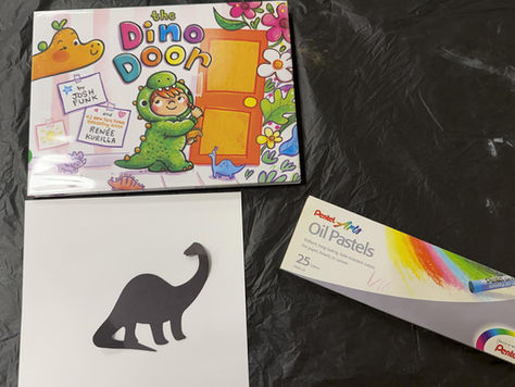 The book cover shows a child in a dinosaur costume holding a crayon and approaching a door, while dinosaurs and flowers peek in from the edges. The book is pictured with a paper dino silhouette, a box of oil pastels, and a plain sheet of paper