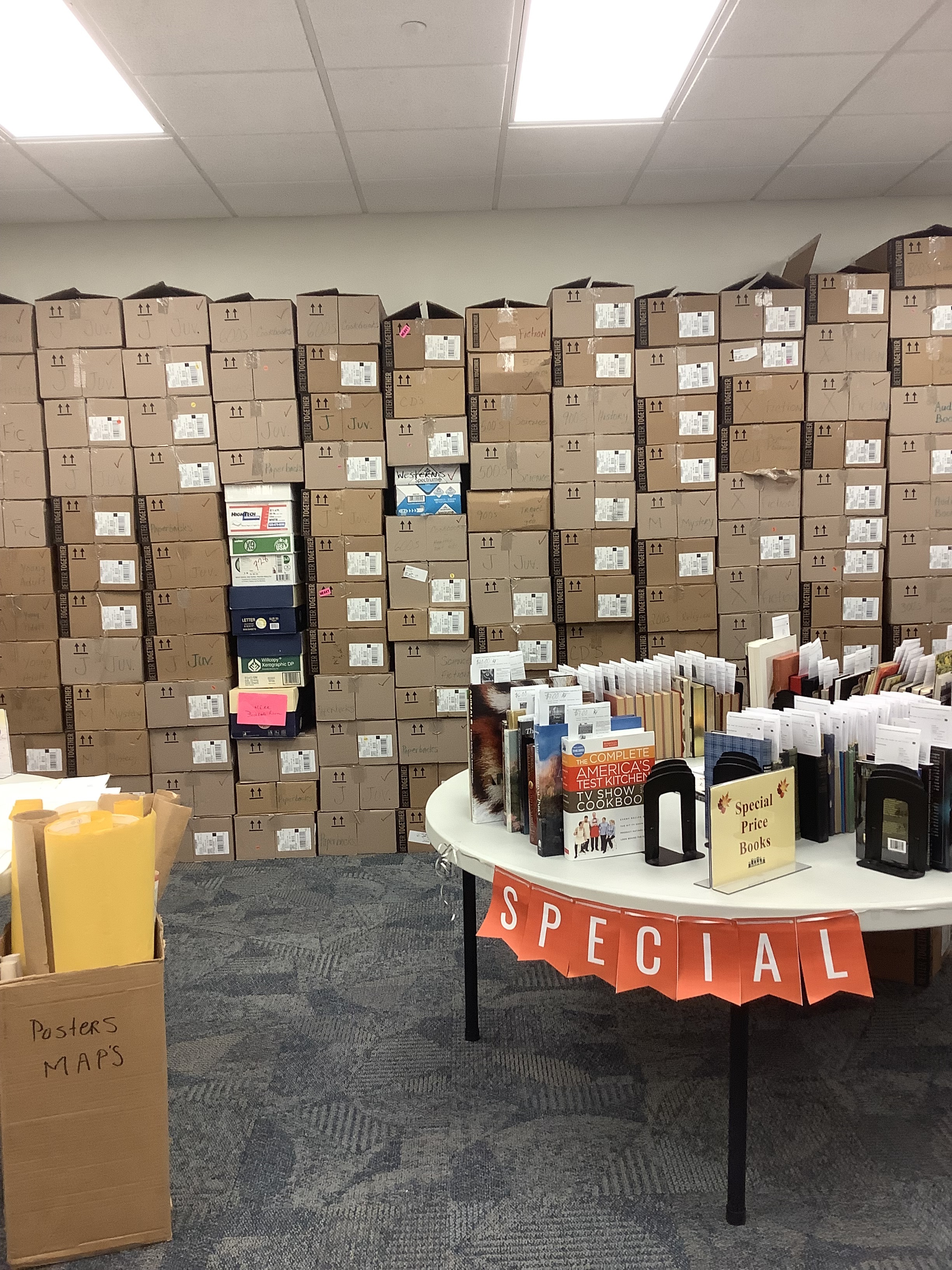 Huge stacks of cardboard book boxes and a round table full of books