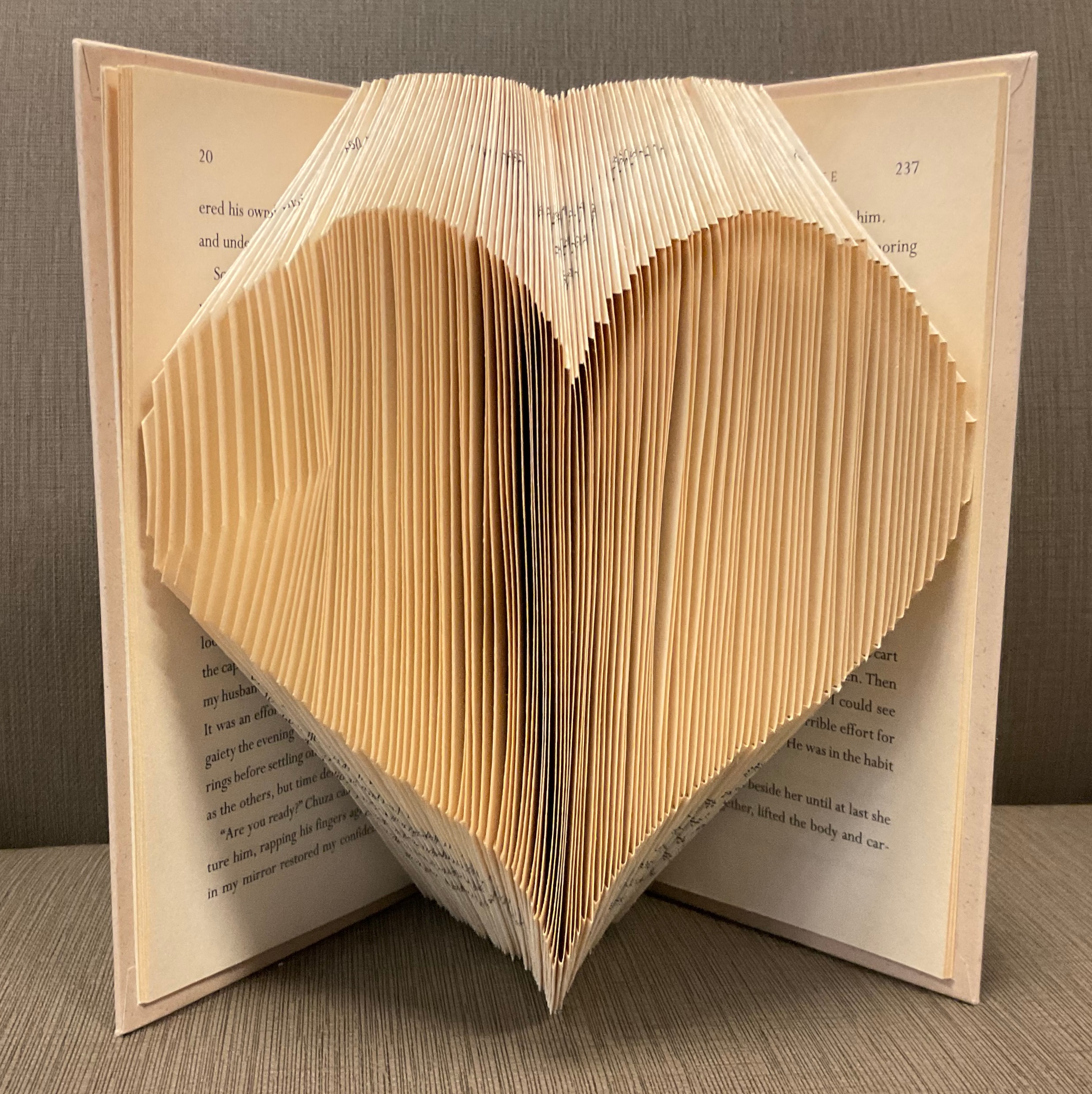 A book with several pages folded in such a way that it looks like a heart is popping out