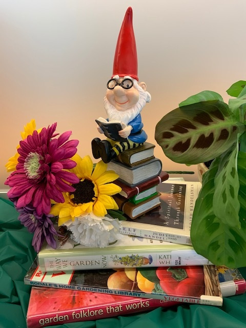 Gnome on top of a stack of gardening books