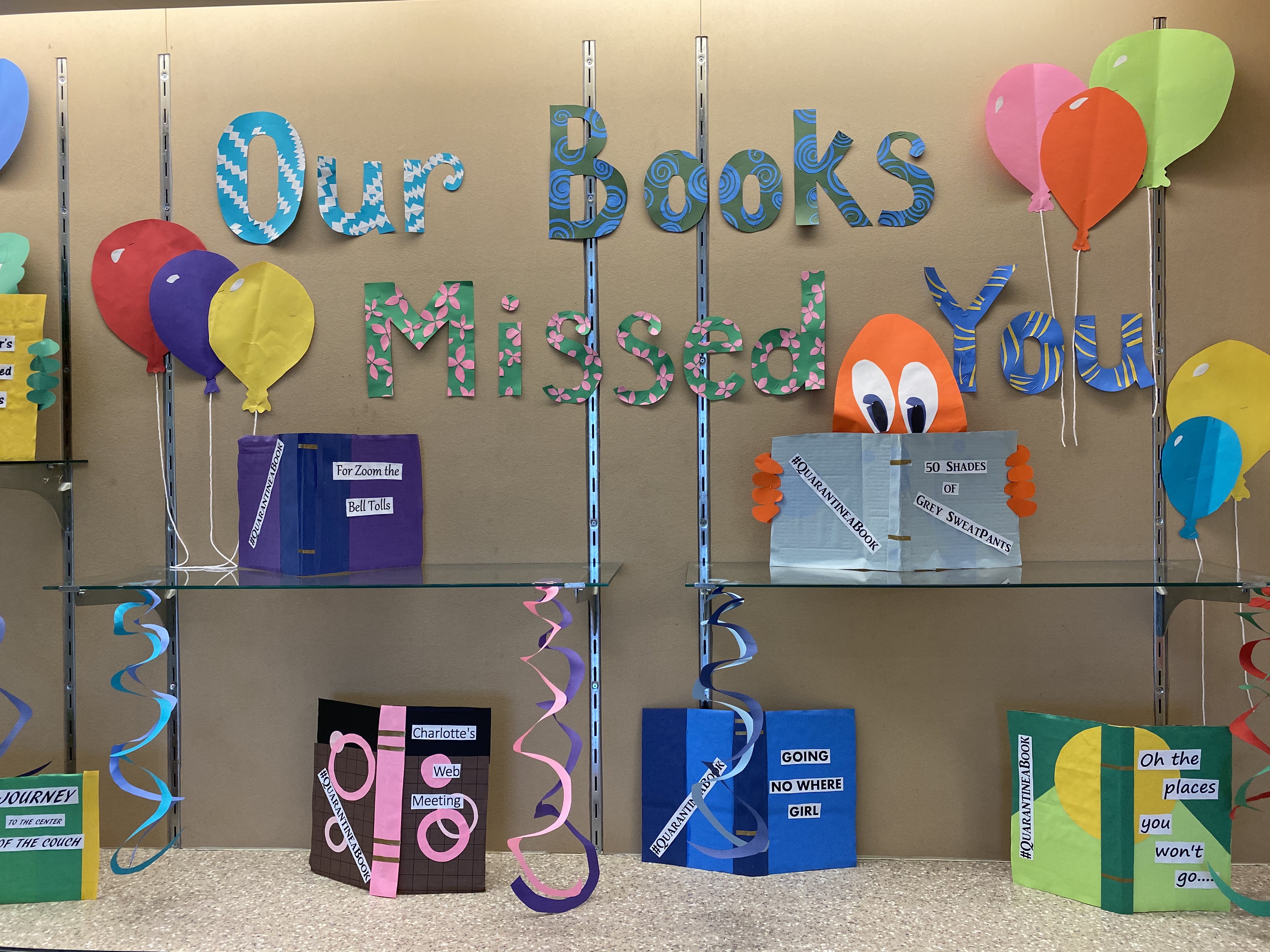 The display case at lake station new chicago branch with paper decorations of books and paper letters spelling Our Books Missed You