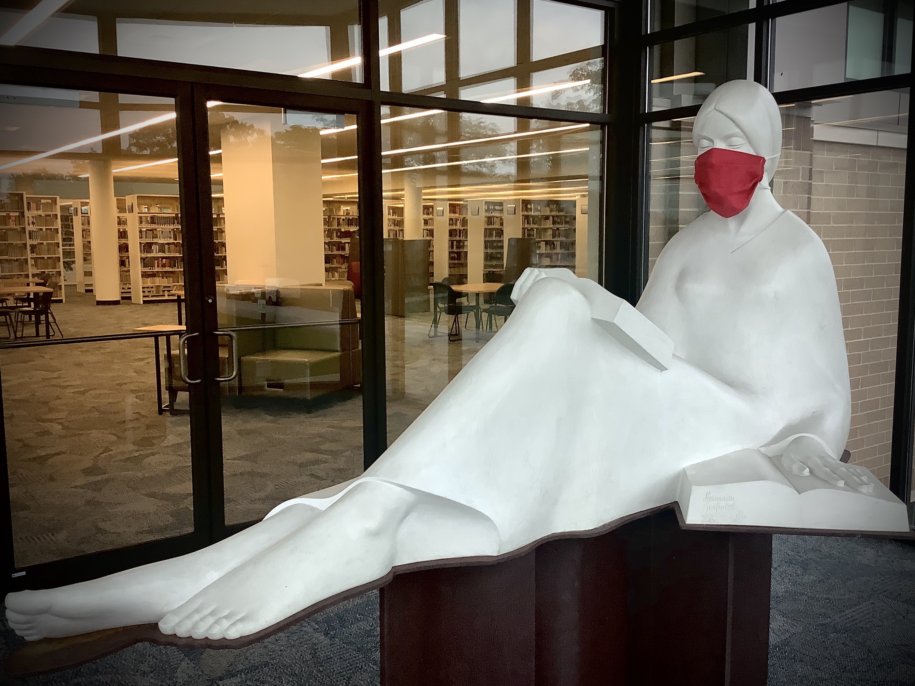 The Reader statue wearing a red mask