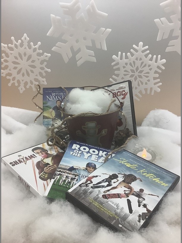 Funny DVDs like Shazam, Rookie of the Year, and Skate Kitchen set on fake snow with snowflakes in the background